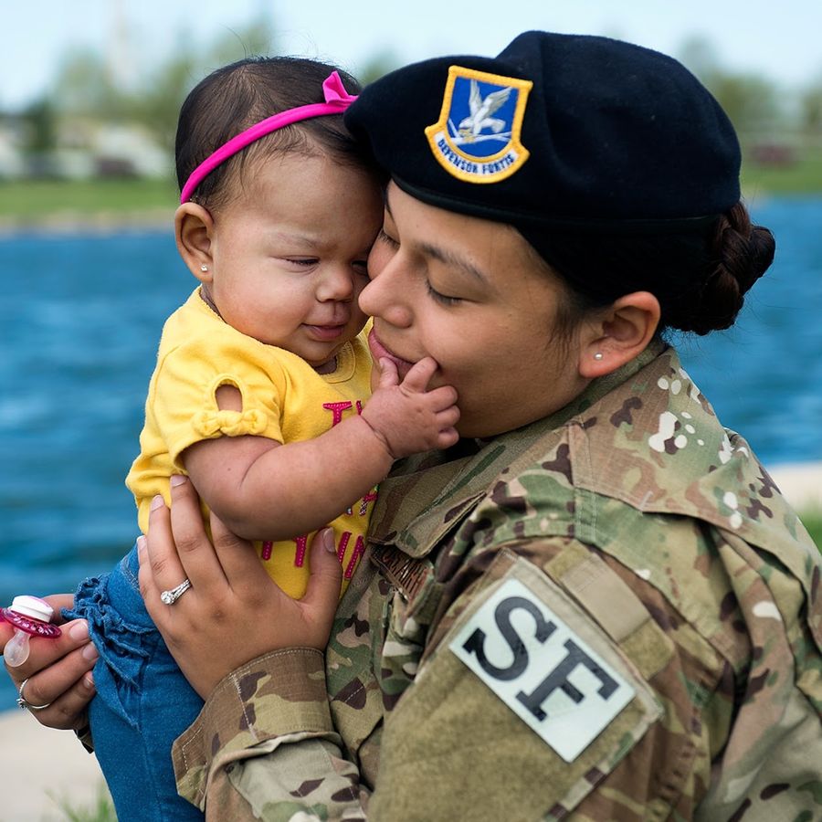 Security Forces Airman holding her infant daughter