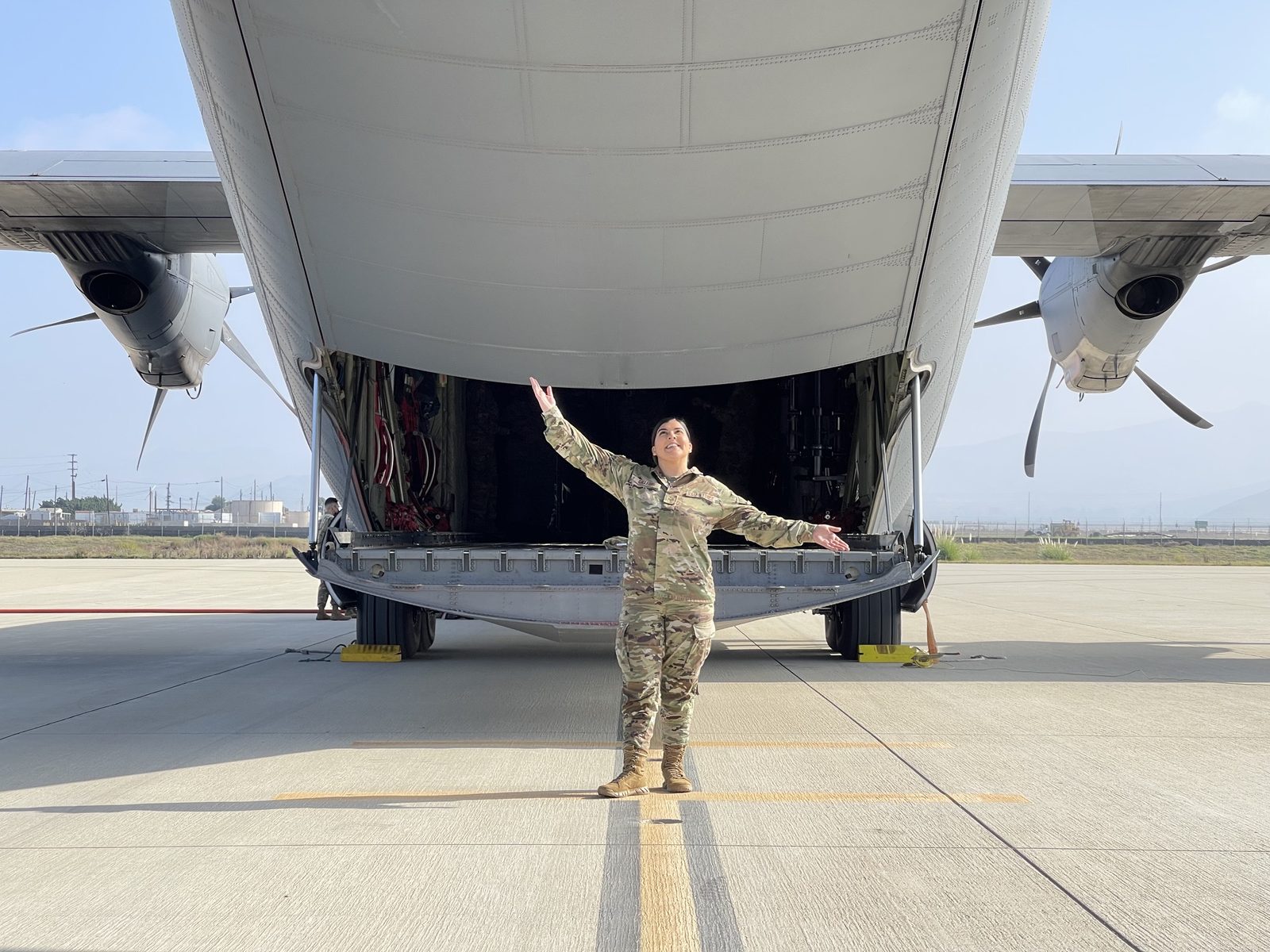 TSgt Jasmin Gallegos under the cargo ramp of a C-130
